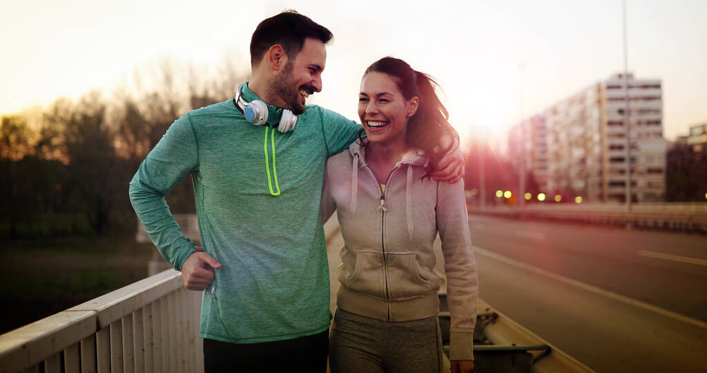 Young attractive couple running outside on sunny day